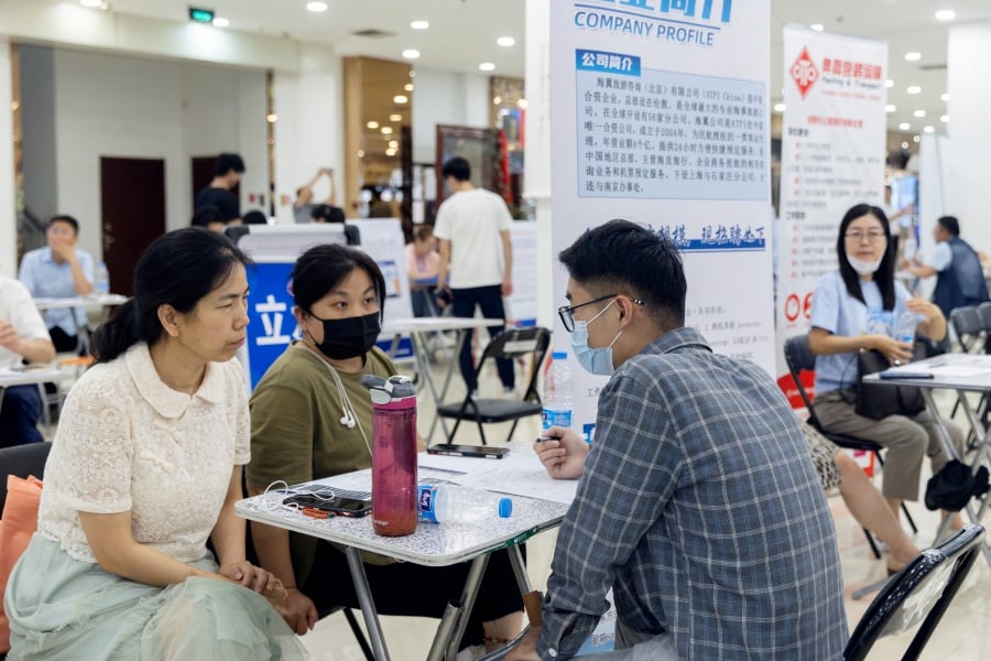 (FILE PHOTO) People attend a job fair in a mall in Beijing, China. (REUTERS/Thomas Peter/File Photo)