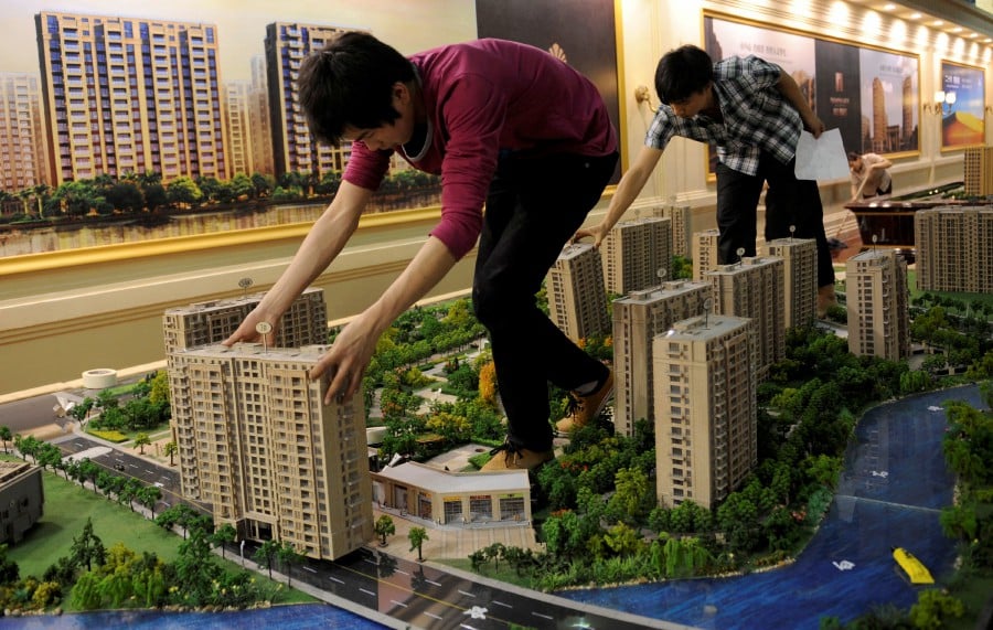 FILE PHOTO: Employees set up model apartments as they prepare a real estate exhibition in Hangzhou, Zhejiang province May 17, 2012. Chinese home prices fell for a second month in April from a year earlier, a trend likely to continue if the government maintains efforts to pull them back to what it calls "reasonable levels" to ease social discontent. Picture taken May 17, 2012. REUTERS/Lang Lang (CHINA - Tags: BUSINESS REAL ESTATE)/File Photo