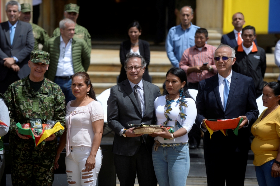 Colombia's Defense Minister Ivan Velasquez and President Gustavo Petro pose for a picture next to women who helped in the rescue of the surviving children from a Cessna 206 plane that crashed in the thick jungle, in Bogota, Colombia. (REUTERS/Vannessa Jimenez)