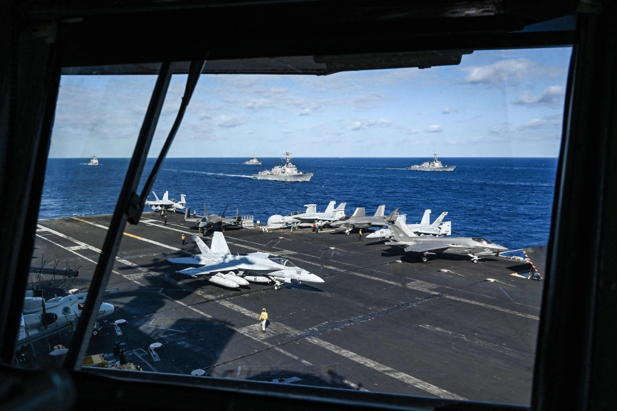 Jet fighters and ships are seen from the bridge of the USS Carl Vinson aircraft carrier during a three-day maritime exercise between the US and Japan in the Philippine Sea. (Photo by Richard A. Brooks / AFP) / 
