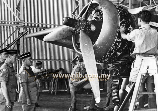 08 December 1964: The Yang di-Pertuan Agong Tuanku Syed Putra Ibni Almarhum Syed Hassan Jamalullail sees RMAF personnel servicing a Pioneer aircraft at one of the hangars at the RMAF station. On the left is Squadron Leader R.E. Melhuish. officer commanding the RMAF Technical Wing. Behind him (partly hidden) is the Station Commander, Wing Commander F.G. Frain.