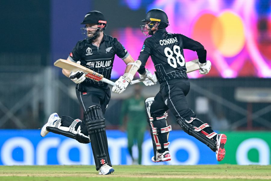 New Zealand's captain Kane Williamson (L) and Devon Conway run between the wickets during the 2023 ICC Men's Cricket World Cup one-day international (ODI) match between New Zealand and Bangladesh on October 13, 2023. - AFP PIC