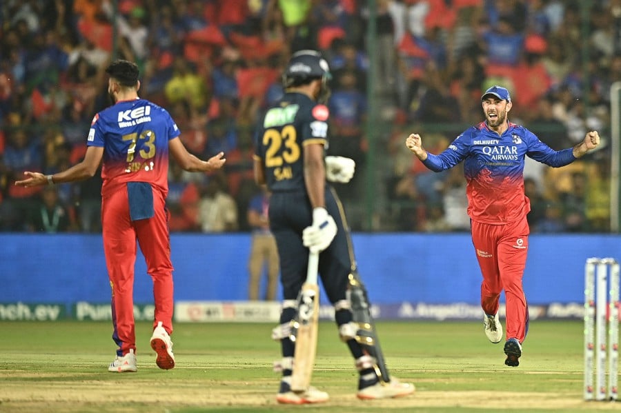 Royal Challengers Bengaluru's Glenn Maxwell (R) and Mohammed Siraj (L) celebrate after the dismissal of Gujarat Titans' captain Shubman Gill during the Indian Premier League (IPL) Twenty20 cricket match between Royal Challengers Bengaluru and Gujarat Titans at the M Chinnaswamy Stadium in Bengaluru on May 4, 2024. AFP PIC