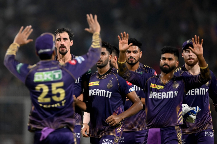 Kolkata Knight Riders' Mitchell Starc (second from left) and Venkatesh Iyer (left) celebrate with teammates after taking the wicket of Delhi Capitals' Jake Fraser-McGurk (not pictured) during the Indian Premier League (IPL) Twenty20 cricket match between Kolkata Knight Riders and Delhi Capitals at the Eden Gardens in Kolkata. (Photo by DIBYANGSHU SARKAR / AFP) 