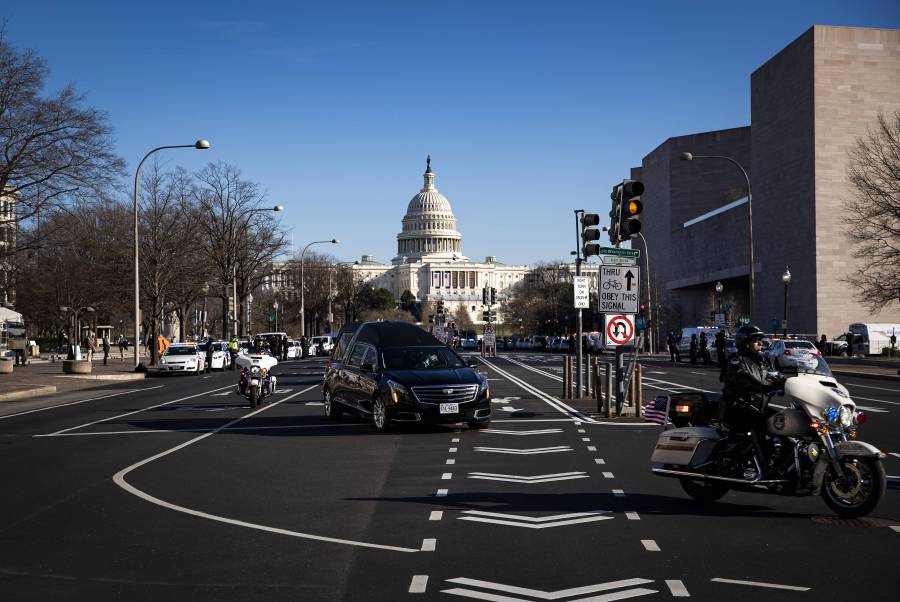A hearse carrying the casket of Brian Sicknick, U.S. Capitol Police Officer who died from injuries following the U.S. Capitol building siege on Wednesday, turns onto Constitution Avenue during a police procession, on January 10, 2021 in Washington, DC. A pro-Trump mob stormed and desecrated the U.S. Capitol on January 6 as Congress held a joint session to ratify President-elect Joe Biden's 306-232 Electoral College win over President Donald Trump. Al Drago/Getty Images/AFP