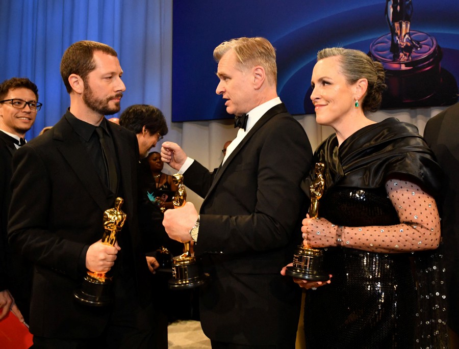 (L-R) Ukrainian filmmaker Mstyslav Chernov, Oscar winner for Best Documentary Feature, talks to British director Christopher Nolan and British producer Emma Thomas, Oscar winners for Best Picture "Oppenheimer," at the 96th Annual Academy Awards Governors Ball at the Dolby Theatre in Hollywood, California. - AFP PIC