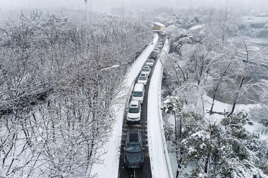 Vehicles make their way amid heavy traffic conditions during snowfall in Wuhan, in central China's Hubei province. - AFP pic