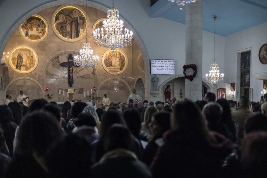 Catholics crowd the Church of Visitation, where the Virgin Mary is believed to have rested during her trip from Nazareth to Bethlehem, in the predominately Christian the village of Zababdeh near Jenin in the occupied West Bank, during Christmas Mass. - AFP pic