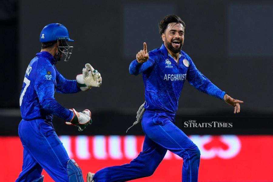 Afghanistan's captain Rashid Khan (right) celebrates the dismissal of Bangladesh's Rishad Hossain during Monday’s T20 World Cup Super Eight match at Arnos Vale Stadium in Arnos Vale, Saint Vincent and the Grenadines. AFP PIC 