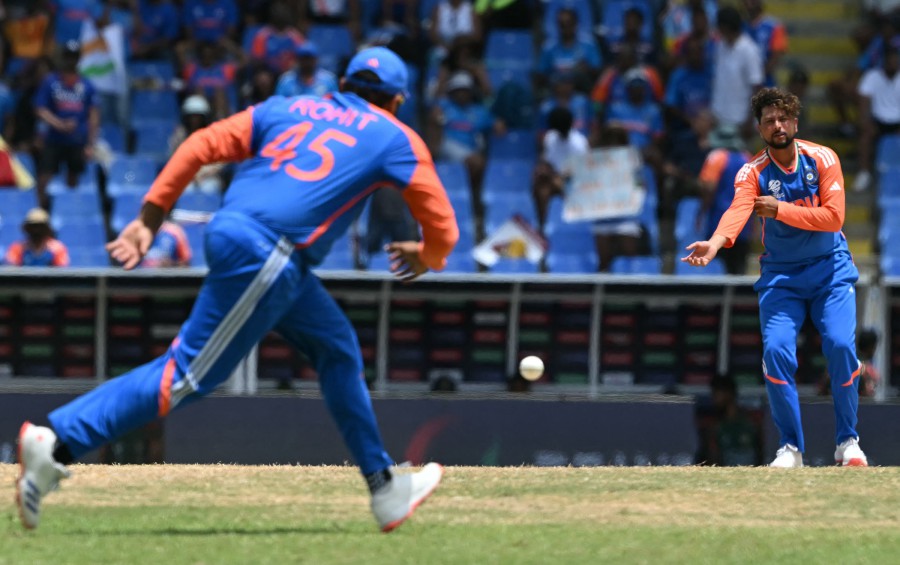 India's Kuldeep Yadav (Right) watches as captain Rohit Sharma fields during the ICC men's Twenty20 World Cup 2024 Super Eight cricket match against Bangladesh at Sir Vivian Richards Stadium in North Sound, Antigua and Barbuda, yesterday (June 22). — AFP