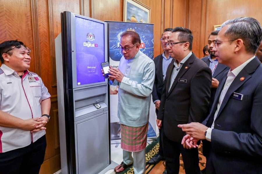PUTRAJAYA, 1 Dis -- Prime Minister Datuk Seri Anwar Ibrahim (second, left) registers with the National Digital Identity or Digital ID at the Perdana Putra Building. - BERNAMA Pic