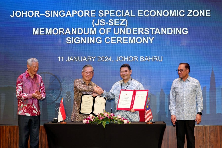 Prime Minister Datuk Seri Anwar Ibrahim (right) and his Singapore counterpart Lee Hsien Loong (left) at the signing of memorandum of understanding (MoU) on Johor-Singapore Special Economic Zone (JS-SEZ) between Economy Minister Rafizi Ramli (second, right) and Singaporean Minister for Trade and Industry Gan Kim Yong (second, left) today. BERNAMA PIC