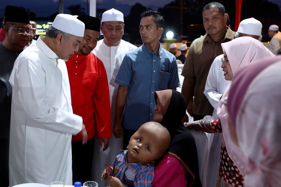 TANAH MERAH: Deputy Prime Minister Datuk Seri Dr Ahmad Zahid Hamidi engages with young child Mohd Faris Ofran Zulkarnain during the Santunan Kasih Ramadan ceremony and event at Masjid Batang Merbau here today (March 16). — FotoBernama
