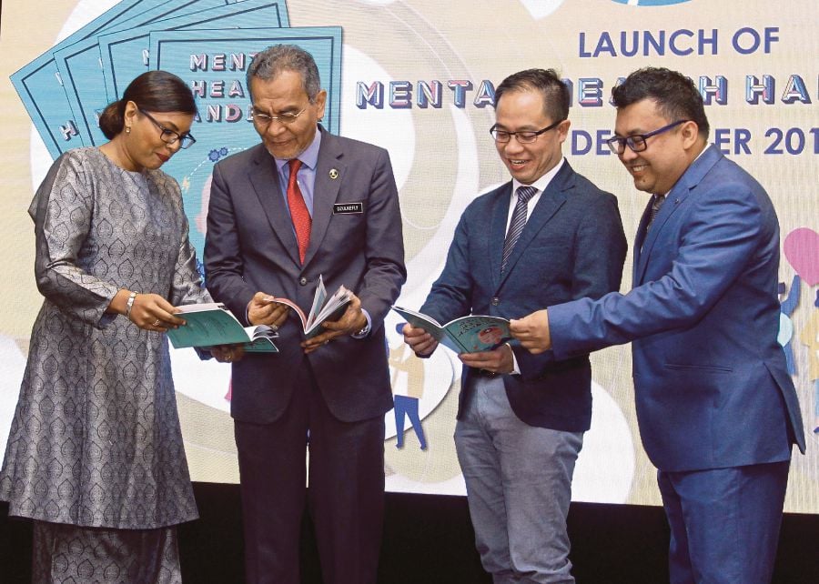  Health Minister Datuk Seri Dr Zulkefly Ahmad (2nd left) looking at the Mental Health Handbook after the launching of Mental Health Book today.-Bernama