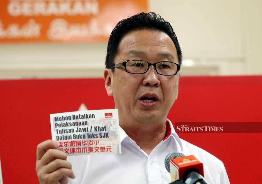 Gerakan President Datuk Dr Dominic Lau showing a postcard bearing the message 'Please Cancel Jawi / Khat Writing in SJK Textbooks' at the party’s Penang headquarters. -NSTP/DANIAL SAAD