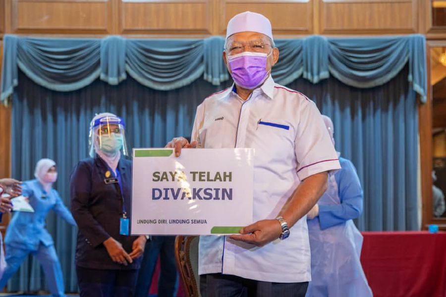 Kelantan Menteri Besar Datuk Ahmad Yakob holds a placard after receiving his first dose of Pfizer-Biontech Covid-19 vaccine on March 2. - Pic source: Facebook/DatoAhmadYakob