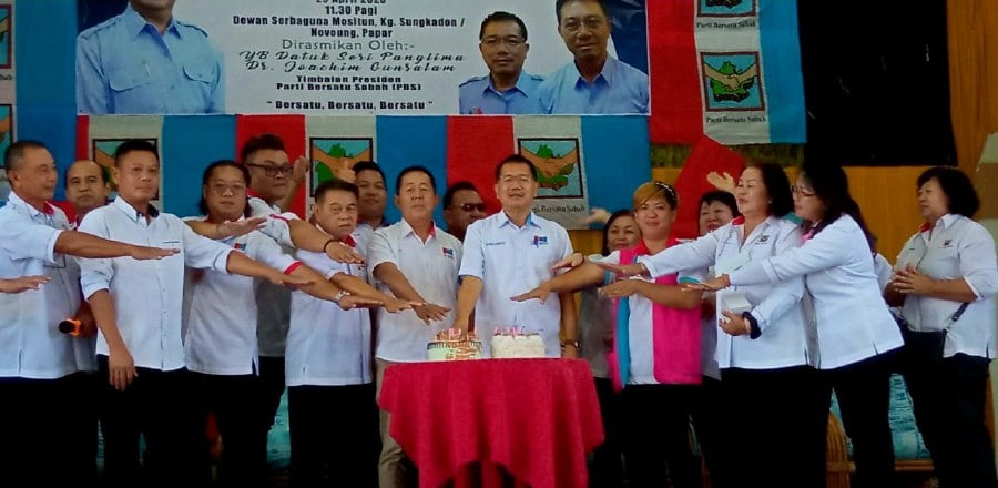PBS vice president Datuk Johnny Mositun (7th, right) and party members jointly cutting the anniversary cake. - Pic  courtesy of PBS. 