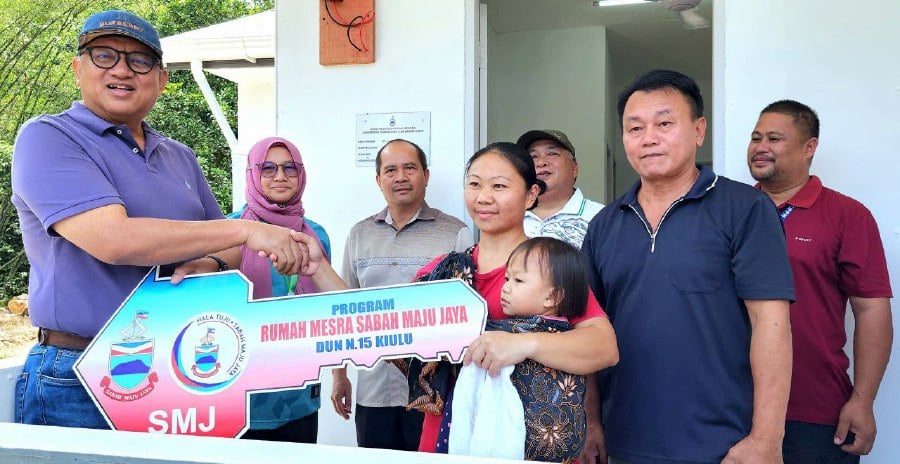 Kiulu assemblyman Datuk Joniston Bangkuai handing over SMj house key to Stella Lonsiun from Kampung Logkou Lama. - Pic courtesy of Datuk Joniston Bangkuai
