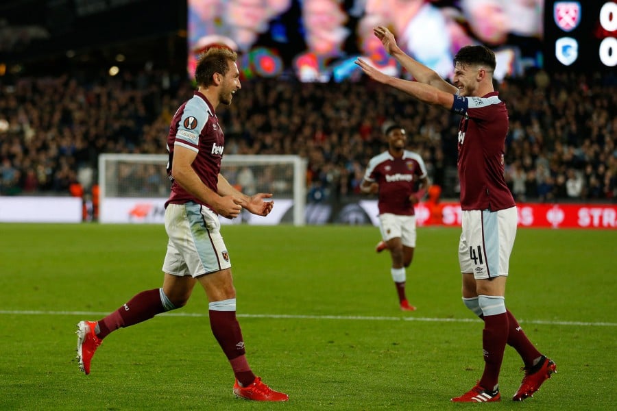 West Ham United's English defender Craig Dawson (L) celebrates with West Ham United's English midfielder Declan Rice (R) after scoring the opening goal of the UEFA Europa League group H football match between West Ham United and Genk at The London Stadium, in east London. - AFP PIC