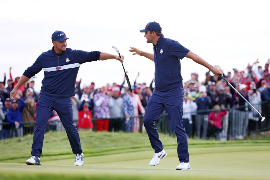 Bryson DeChambeau o(L) and Scottie Scheffler of team United States celebrate on the 15th green during Saturday Afternoon Fourball Matches of the 43rd Ryder Cup at Whistling Straits on September 25, 2021 in Kohler, Wisconsin. - AFP PIC