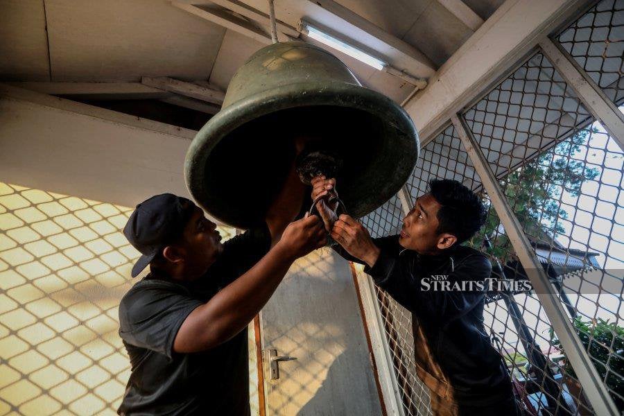 Muhammad Muizzuddin Mansur (left) and Muhammad Hamidi Aminuddin ring the bell before the breaking of fast - NSTP/Ghazali Kori
