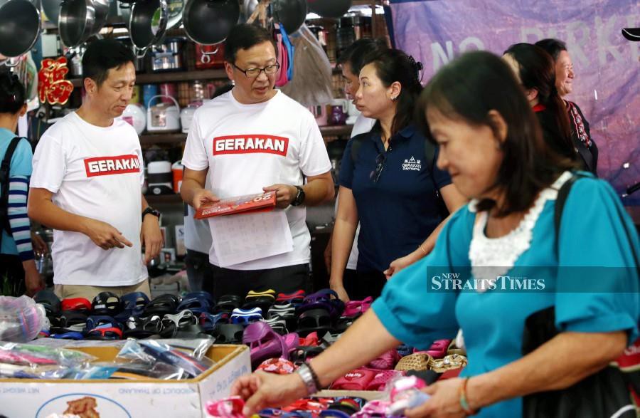 Gerakan president Datuk Dr Dominic Lau (centre) mingles with locals at Lebuh Cecil market. -NSTP/Danial Saad