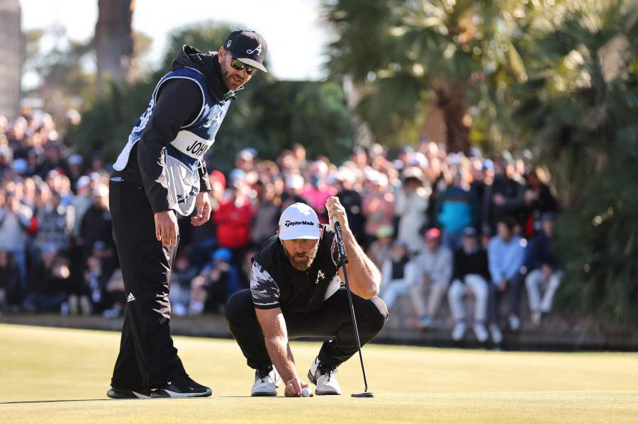 Captain Dustin Johnson of 4Aces GC talks with his caddie and brother, Austin Johnson, on the 18th green during day three of the LIV Golf Invitational - Las Vegas at Las Vegas Country Club on February 10, 2024 in Las Vegas, Nevada. - Michael Reaves/Getty Images/AFP 