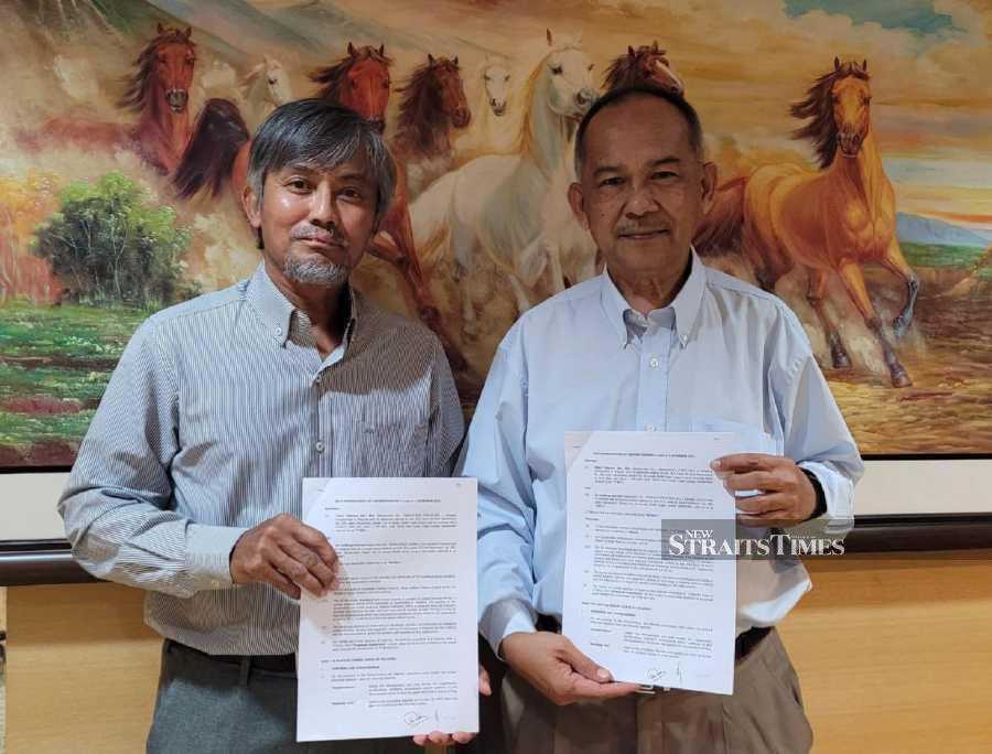 EA Holdings Bhd chief executive officer Mohammad Sobri Saad (left) holding the signed MoU with Third Telecom Sdn Bhd chief executive officer Aminuddin Abu Khalid (right). 