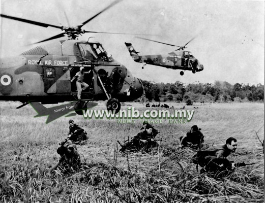 13 May 1970: With the down blast from the rotor of a Royal Air Force Wessex helicopter beating down on them, infantrymen of the Australian-New Zealand Battalion prepare to attack immediately after landing. They are taking part in miltary exercise "Short Gallop", near Mersing on the east coast of West Malaysia. "Short Gallop" is a preparatory exercise forming part of Exercise Bersatu Padu.