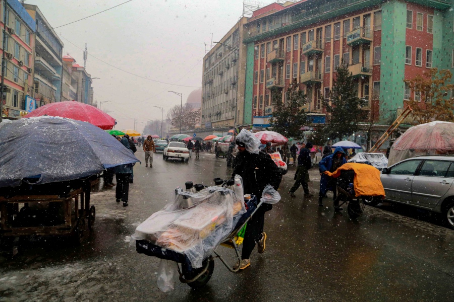 Pedestrians pass street vendors as snow falls in Kabul, Afghanistan, 03 January 2022. Afghanistan has been battling an acute humanitarian crisis since the fall of Kabul to the Islamist Taliban militia on August 15. Acute food shortages fueled by drought, lack of cash, the pandemic, and crippled health services have piled up miseries on the people of Afghanistan. - EPA pic