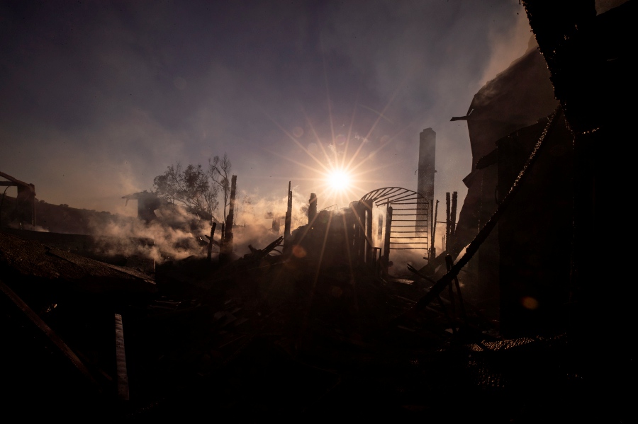 The sun is shinning through the smoke and rubbles of a burnt down house as the Sycamore Fire is burning in Whittier, East of Los Angeles, California. - EPA Pic