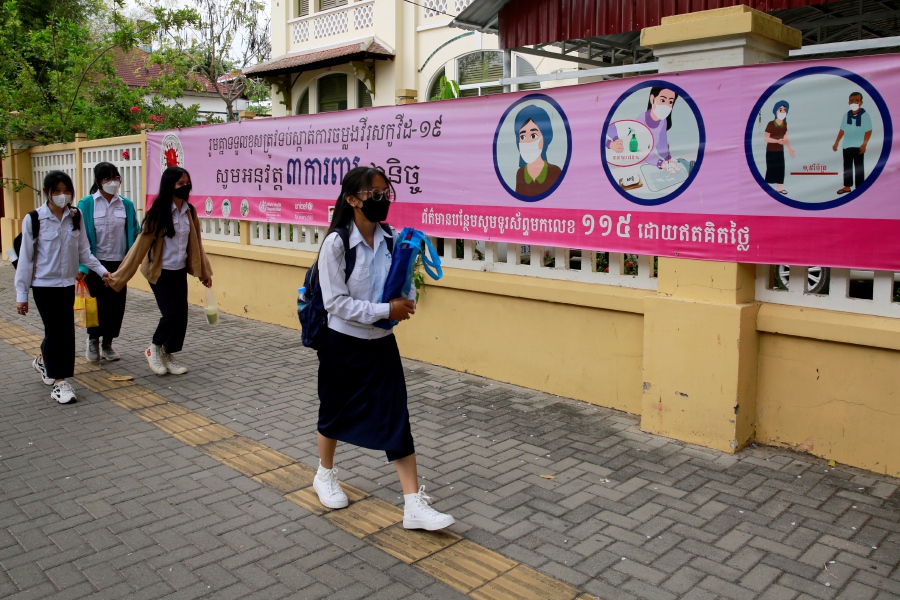 Cambodian students walk past a banner giving information about the COVID-19 pandemic, in Phnom Penh, Cambodia, 15 March 2022. According to a press release by Cambodia's Health Ministry on 14 March, the Ministry urged all cities and provincial governors to start implementing outreach education campaigns to educate people about the danger of COVID-19's new variant Omicron, and to learn how to live under the current pandemic situation. - EPA pic 