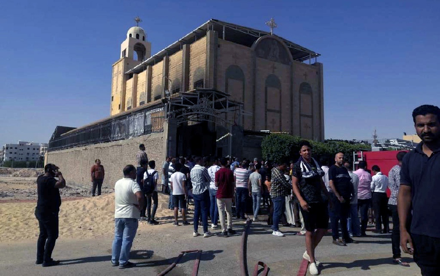 People stand outside the Anba Bishoy church after a fire broke out, in New Minya governorate, Egypt. - EPA Pic