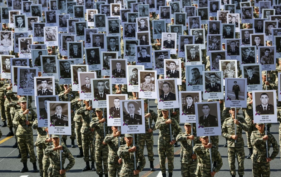 Azeri soldiers carry portraits of the servicemen and civil people who was killed during the Second Karabakh War at the commemorative march on the anniversary of the start of the war in downtown of Baku, Azerbaijan. -EPA Pic