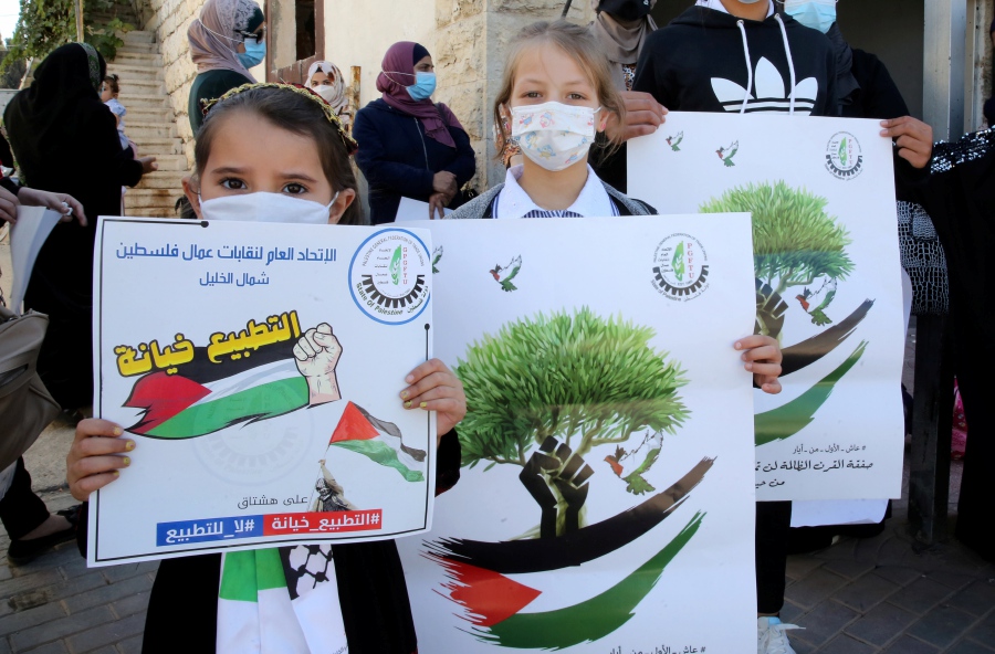 Palestinian children hold banners during a demonstration of the women committee of the Fateh movement, to reject The Bahrain and UAE normalization agreement with Israel, in the village of Halhul, West Bank city of Hebron. EPA/ABED AL HASHLAMOUN