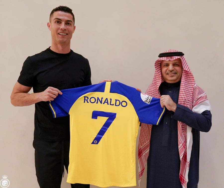 Cristiano Ronaldo holds Al Nassr no7 jersey after contract signed