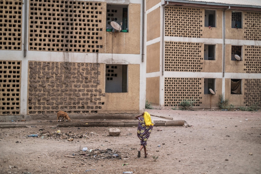 A girl runs in a compound of abandoned buildings, where internally displaced people are sheltered, near the town of Dubti, 10 kilometers from Semera, Ethiopia, on June 7, 2022. - (Photo by EDUARDO SOTERAS / AFP)