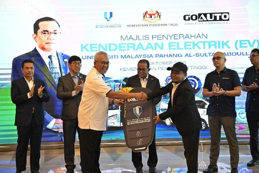 Go Automobile Manufacturing Sdn Bhd executive director Wan Ahmad Wan Omar (right) handing the replica key to Yuserrie (left, in white) while Higher Education minister Datuk Seri Mohamed Khaled Nordin (middle) looks on. - Pic courtesy of UMPSA