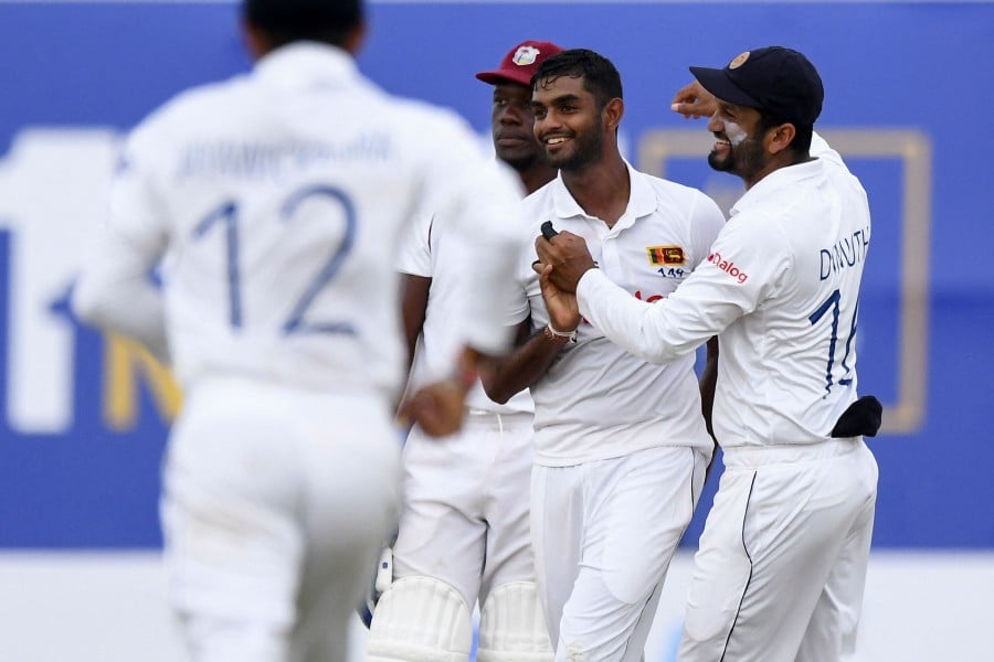 Sri Lanka's Lasith Embuldeniya (2R) celebrates with teammates after the dismissal of West Indies' Roston Chase during the fourth day of the first Test cricket match between Sri Lanka and West Indies at the Galle International Cricket Stadium in Galle. - AFP PIC