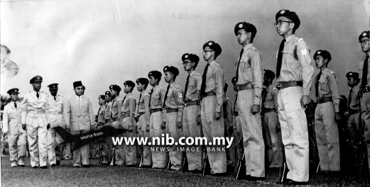 Undated: The Deputy Prime Minister and Minister of Defence Tun Abdul Razak Hussein braving the drizzle to inspect a parade of 200 boys of the Federation Air Training Corps in Kuala Lumpur. The parade marked the end of the corps annual training camp which began on December 6. Three squadrons from Penang, Ipoh and Kuala Lumpur took part in the training.