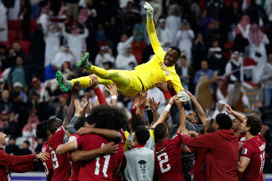 Qatar's players lift their teammate goalkeeper #22 Meshaal Barsham after winning the Qatar 2023 AFC Asian Cup quarter-final football match between Qatar and Uzbekistan on February 3, 2024. - AFP pic