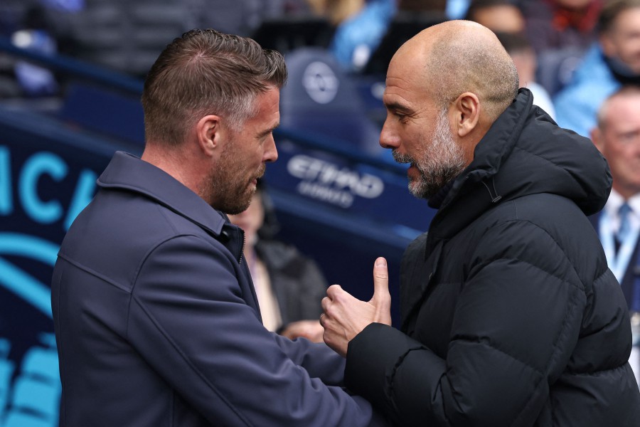 Luton Town's Welsh manager Rob Edwards (L) speaks with Manchester City's Spanish manager Pep Guardiola (R) ahead of kick-off in the English Premier League football match between Manchester City and Luton Town at the Etihad Stadium in Manchester, north west England, on April 13, 2024. AFP PIC