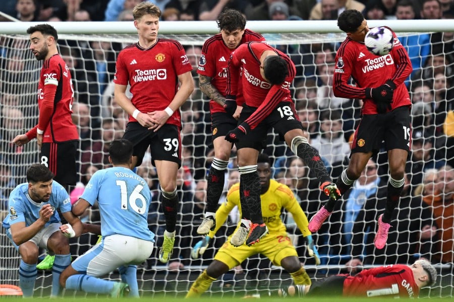 Manchester United's Brazilian midfielder #18 Casemiro (2 right) blocks a freekick taken by Manchester City's Belgian midfielder #17 Kevin De Bruyne during the English Premier League football match between Manchester City and Manchester United at the Etihad Stadium in Manchester, north west England. - AFP pic