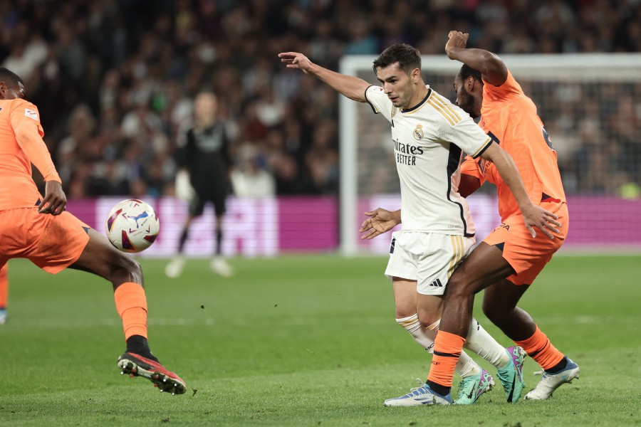 Valencia's French defender Dimitri Foulquier (right) challenges Real Madrid's Spanish forward Brahim Diaz during the Spanish league football match between Real Madrid CF and Valencia CF at the Santiago Bernabeu stadium in Madrid. - AFP pic