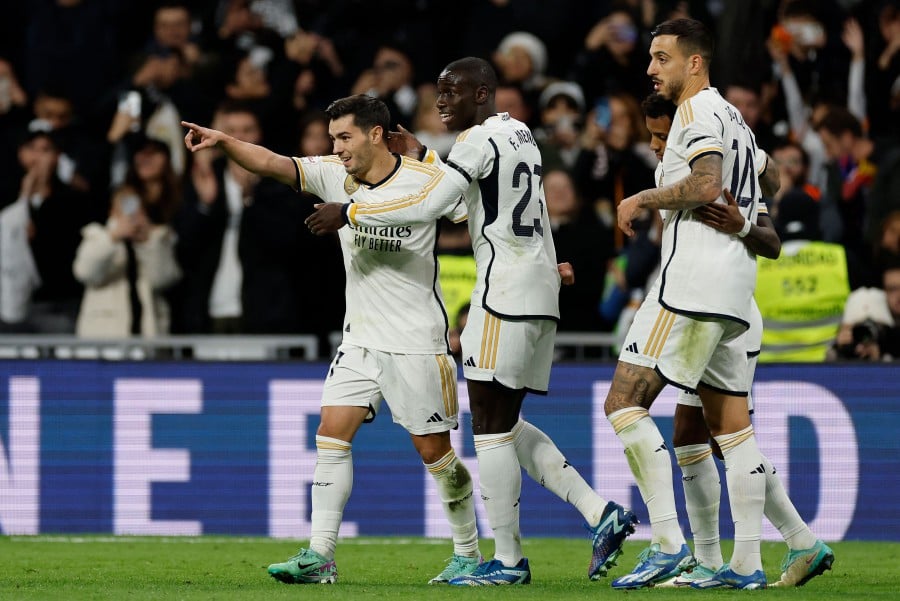 Real Madrid's Spanish forward Brahim Diaz celebrates with Real Madrid's French defender Ferland Mendy after scoring his team's first goal during the Spanish league football match between Real Madrid CF and Granada FC at the Santiago Bernabeu stadium in Madrid. - AFP pic