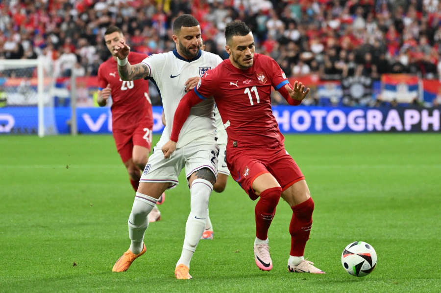 Serbia's forward (right) Filip Kostic and England's defender (left) Kyle Walker vie during the UEFA Euro 2024 Group C football match between Serbia and England at the Arena AufSchalke in Gelsenkirchen. (Photo by Alberto PIZZOLI / AFP)
