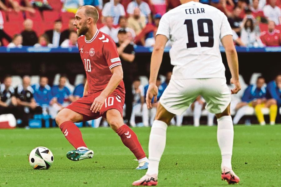 Denmark's midfielder Christian Eriksen (left) runs with the ball during the UEFA Euro 2024 Group C football match between Slovenia and Denmark at the Stuttgart Arena in Stuttgart. (Photo by Miguel MEDINA / AFP)