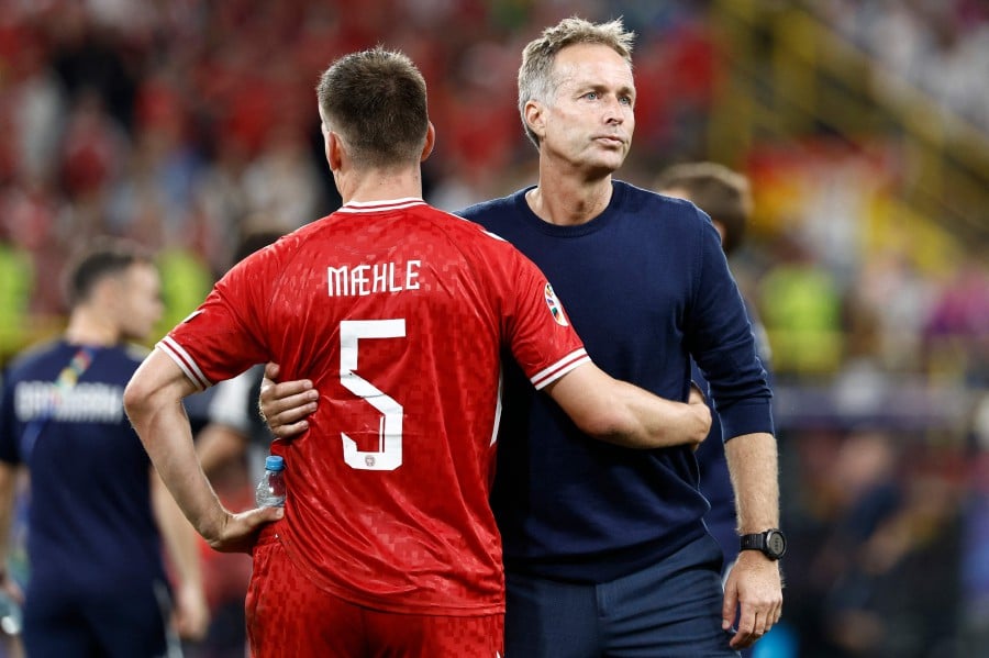 Denmark's head coach Kasper Hjulmand embraces his team player defender #05 Joakim Maehle at the end of the UEFA Euro 2024 round of 16 football match between Germany and Denmark at the BVB Stadion Dortmund in Dortmund on June 29, 2024. AFP PIC
