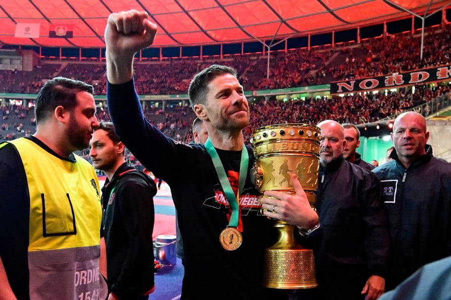 Bayer Leverkusen's Spanish head coach Xabi Alonso celebrates with the trophy after the German Cup (DFB-Pokal) final football match between 1 FC Kaiserslautern and Bayer 04 Leverkusen at the Olympic Stadium in Berlin on May 25, 2024. AFP PIC