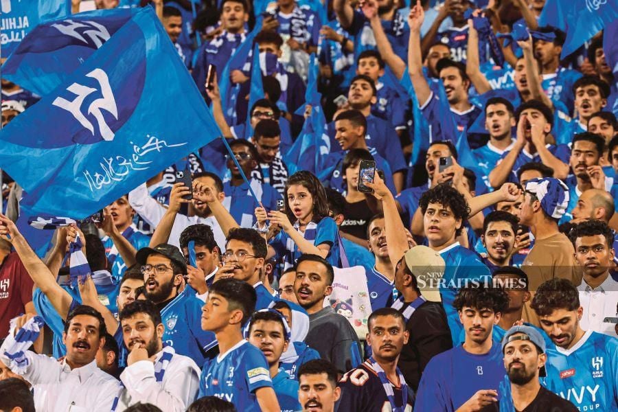 Al Hilal supporters cheer as they celebrate their team's 19th Saudi Pro League title after the match against Al-Hazem at the Kingdom Arena Stadium in Riyadh on Friday. AFP PIC 